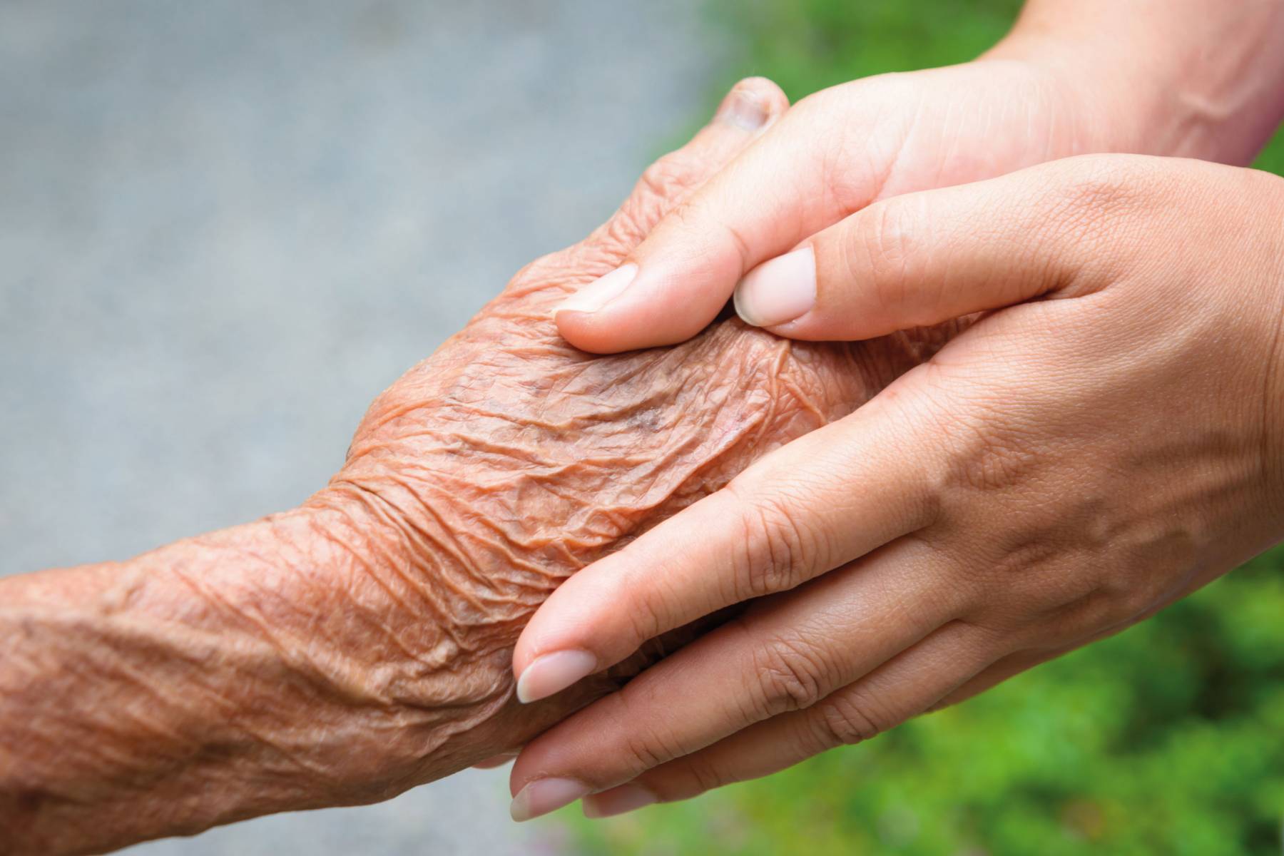 hand bejaarde en zorggever